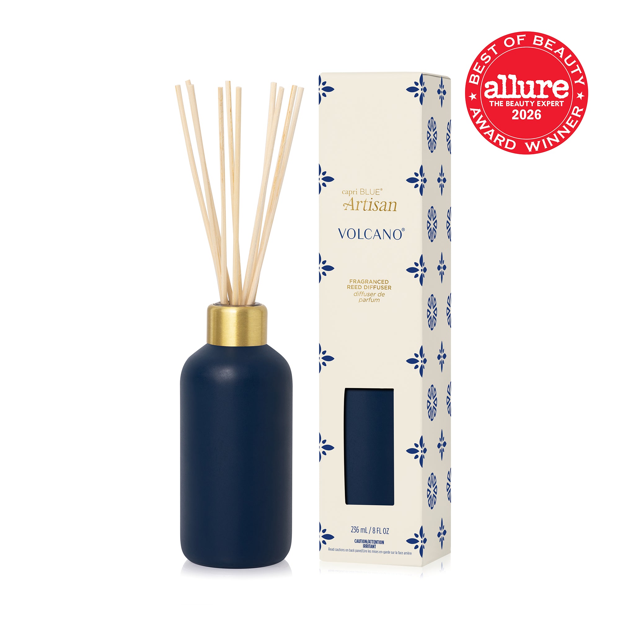 A navy blue reed diffuser bottle with natural wood reeds and a gold collar, shown next to its cream-colored packaging box and the Allure 2026 Best of Beauty Award Winner seal.