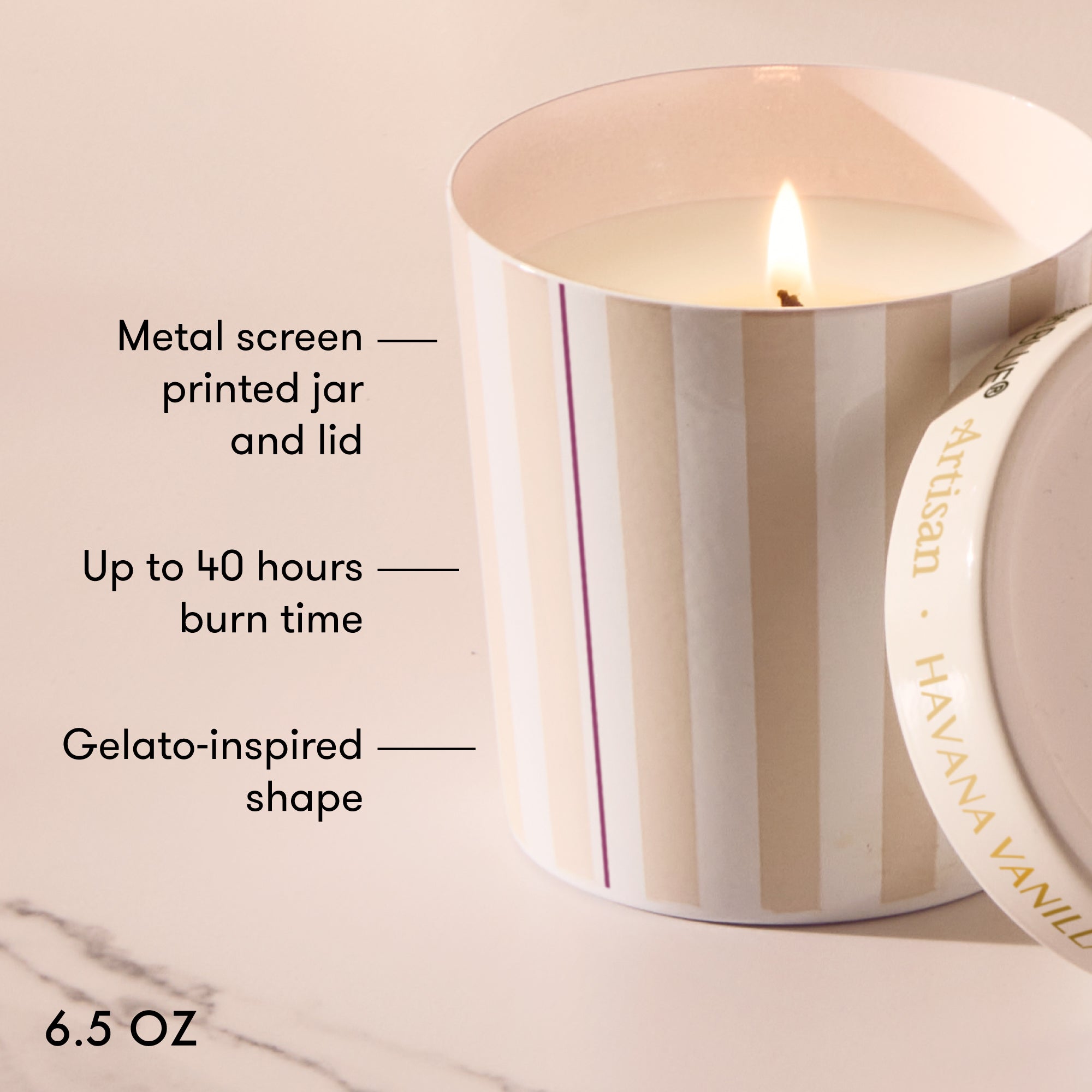 Striped candle with text detailing features on a marble surface