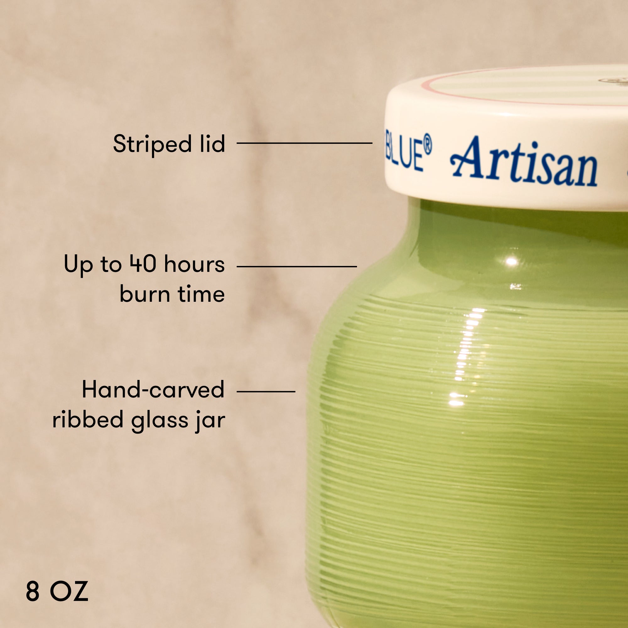 Green glass jar with a striped lid labeled 'Artisan' on a beige background.