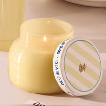 Yellow ceramic jar with a striped label on a beige background