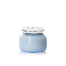 Blue candle jar with a white label on a white background