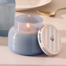 Blue candle with 'Artisan Volcano' label on a white surface
