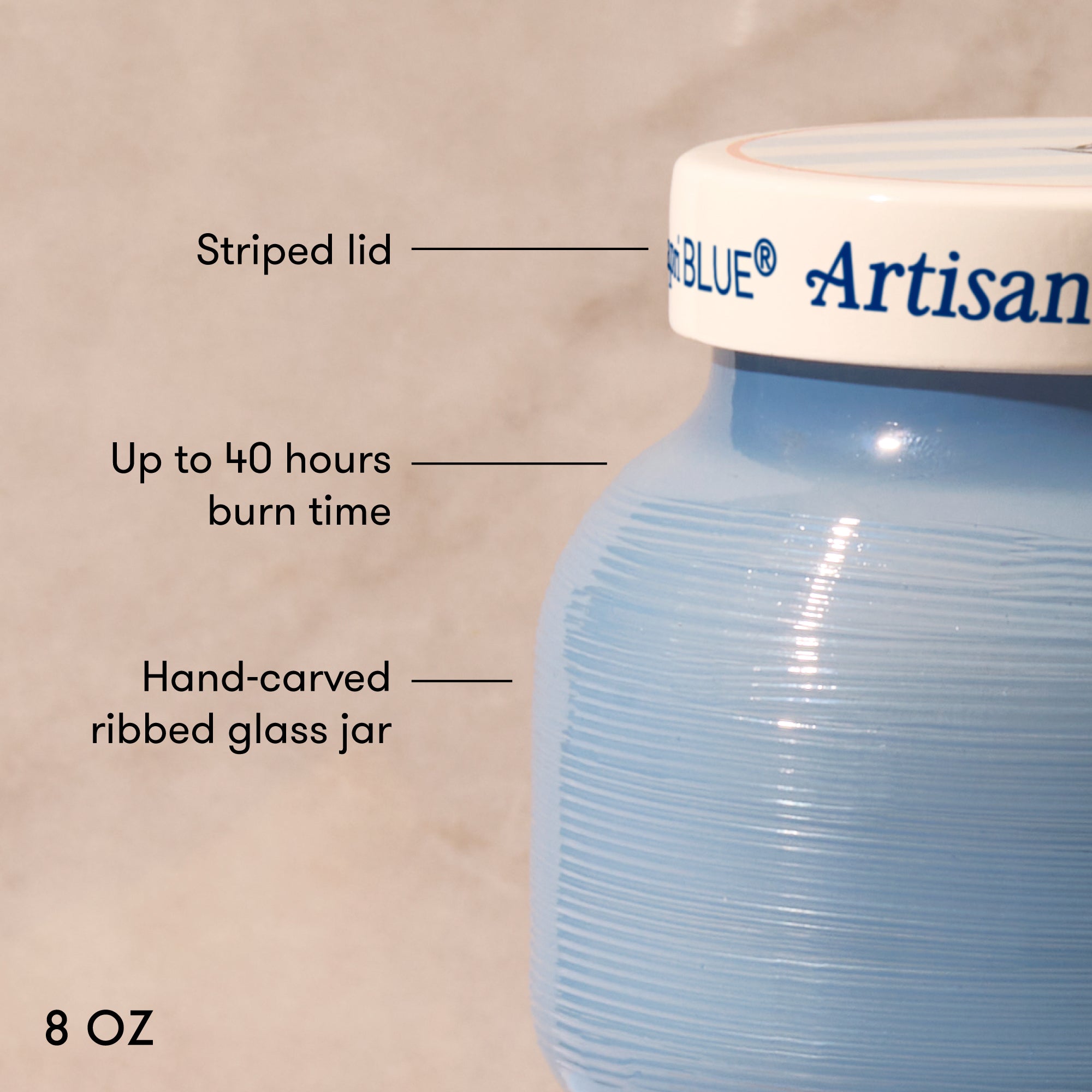 Blue Artisan candle jar with labeled features on a beige background