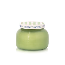 Green candle with a white and green striped lid on a white background