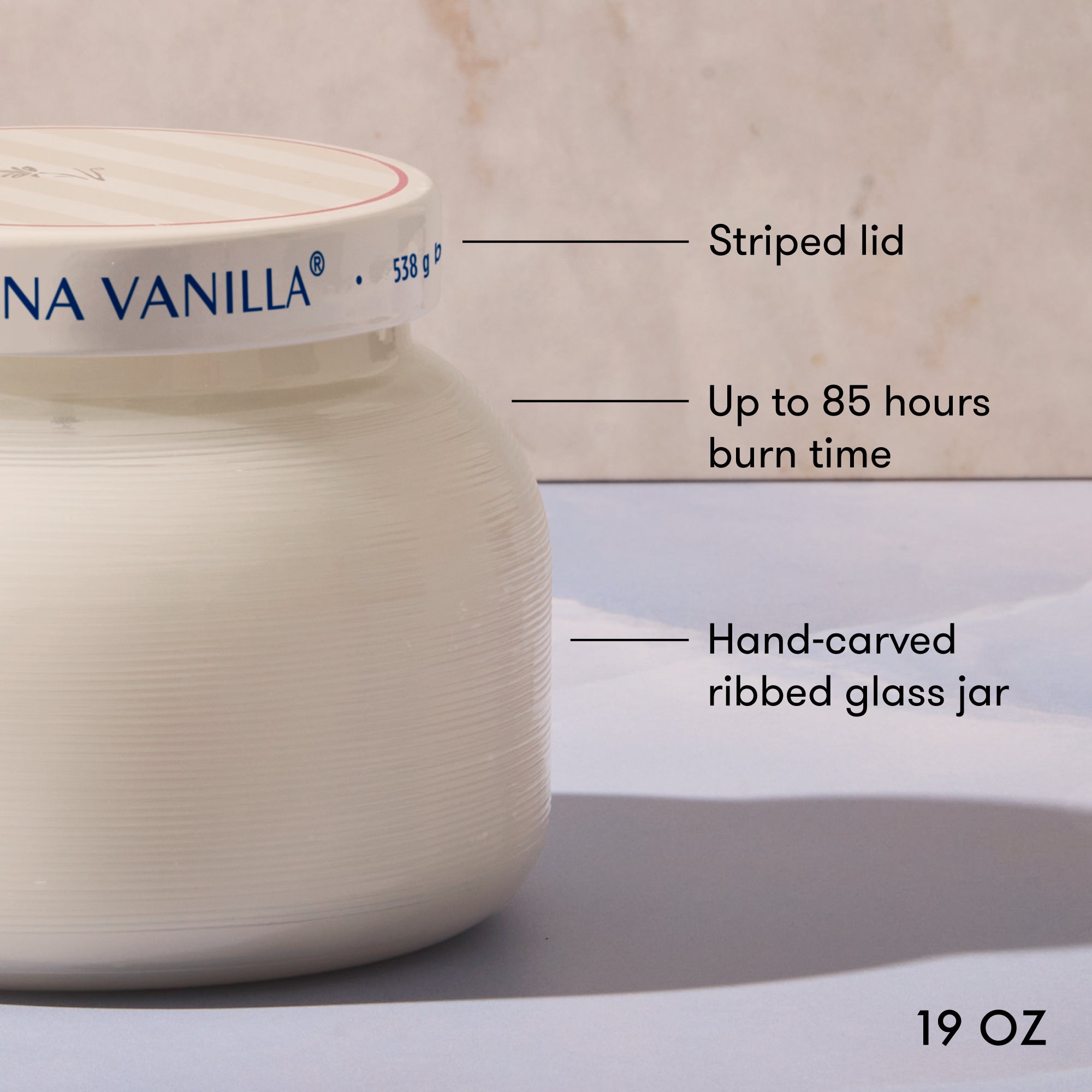 Candle jar with labeled features on a neutral background