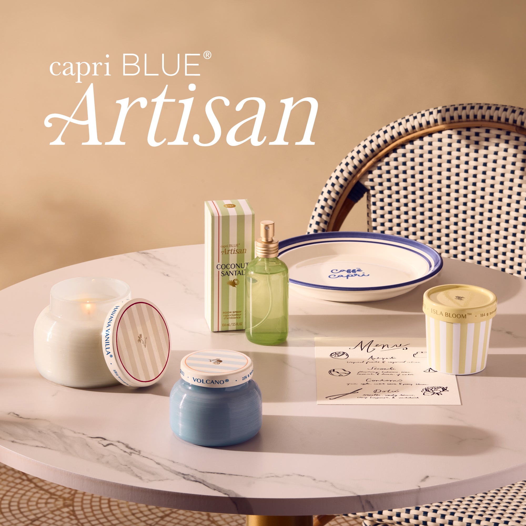 capri BLUE Artisan products including candles and bottles on a marble surface with a beige background.