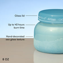Blue glass jar with a lid, labeled with features like 'Glass lid', 'Up to 40 hours burn time', 'Hand-decorated sea glass texture', and '8 OZ'.