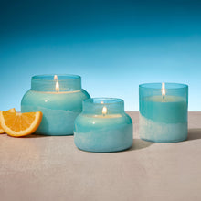 Three turquoise candles with a blue background