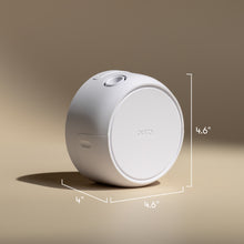 White cylindrical device with 'Ouya' branding and dimensions on a beige background
