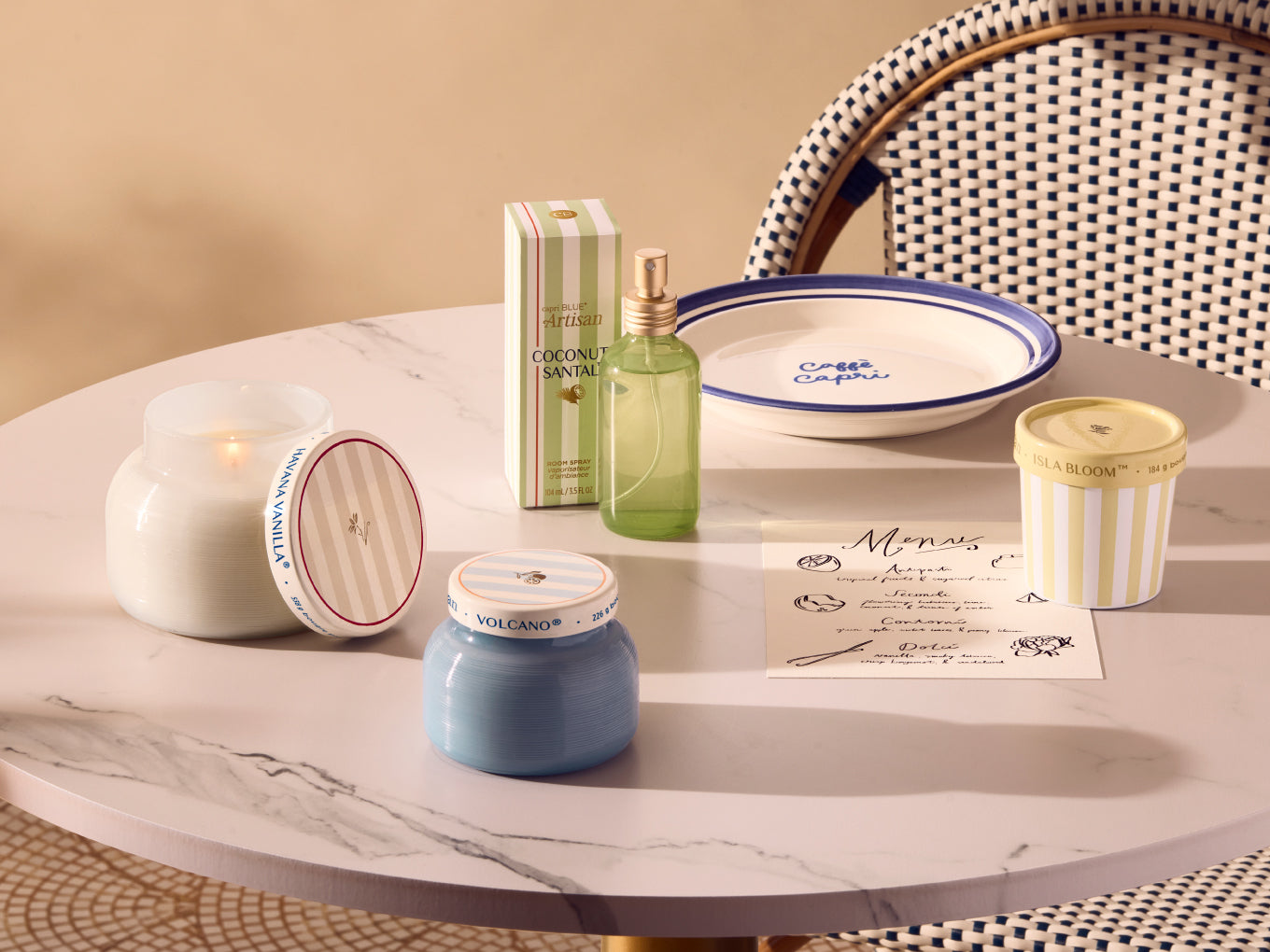 Decorative items including candles and a bottle on a marble surface with a chair in the background.