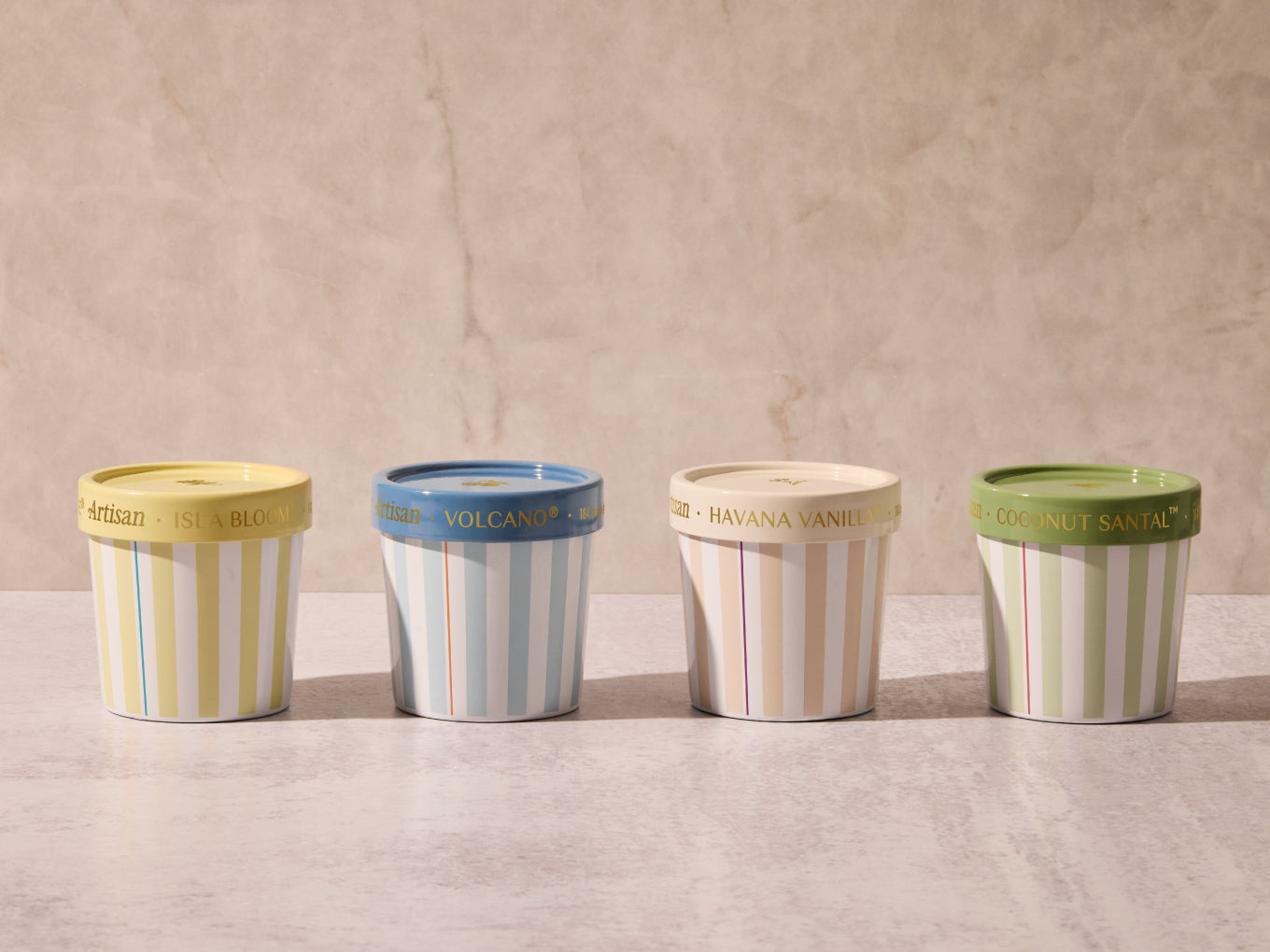 Four ice cream containers with striped designs on a neutral background