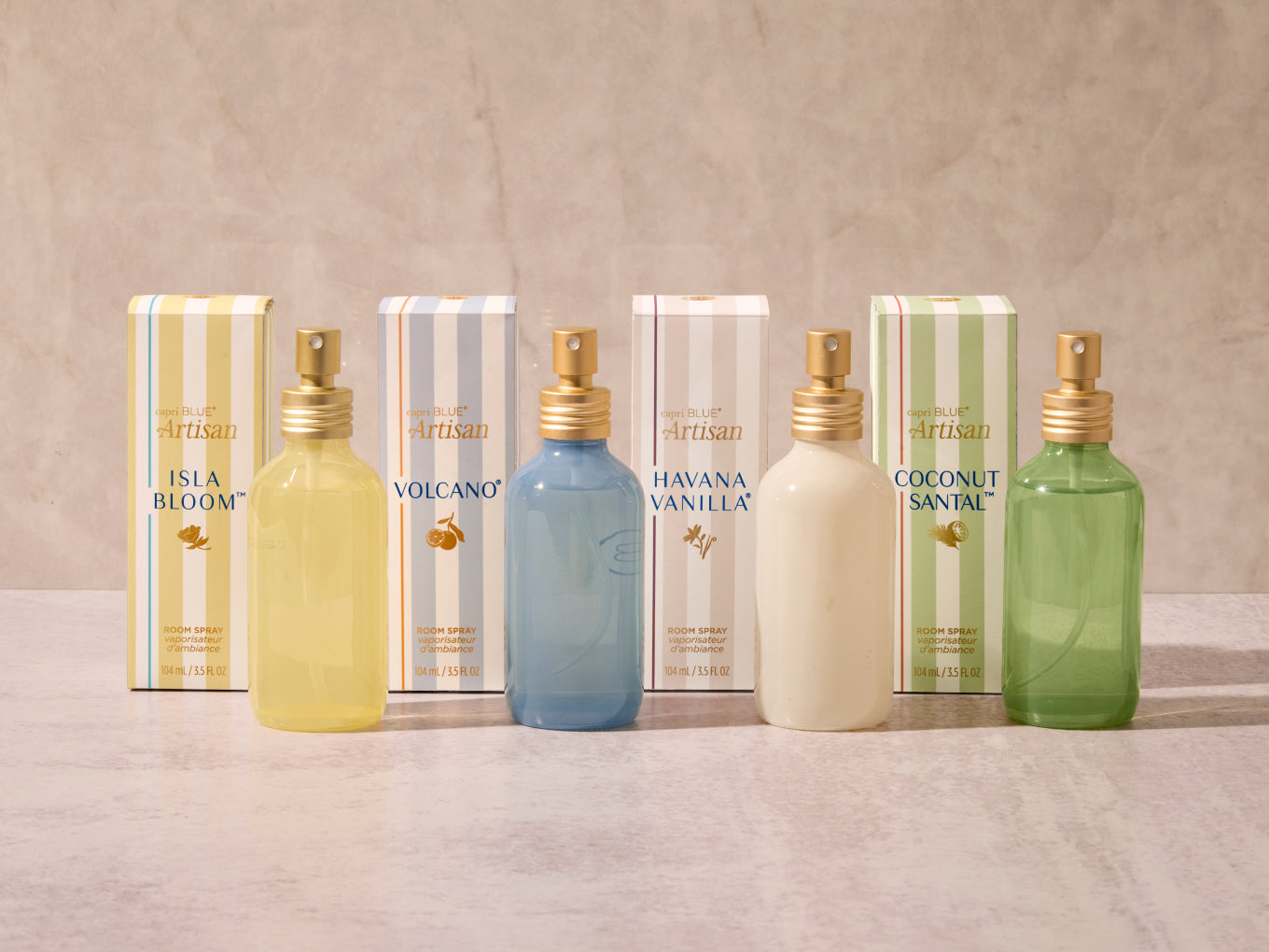 Four spray bottles with different colored liquids and gold nozzles, each paired with a box labeled 'Artisan'.