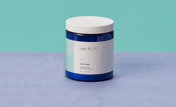 Capri Blue candle jar on a blue and green background