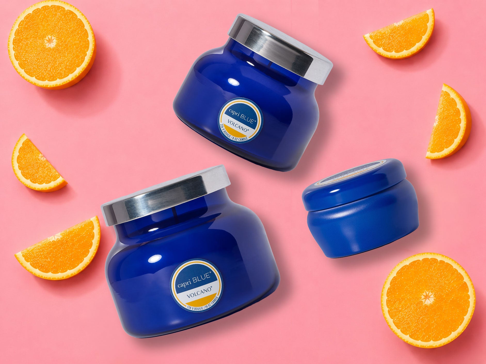 Blue jars with silver lids on a pink background with orange slices