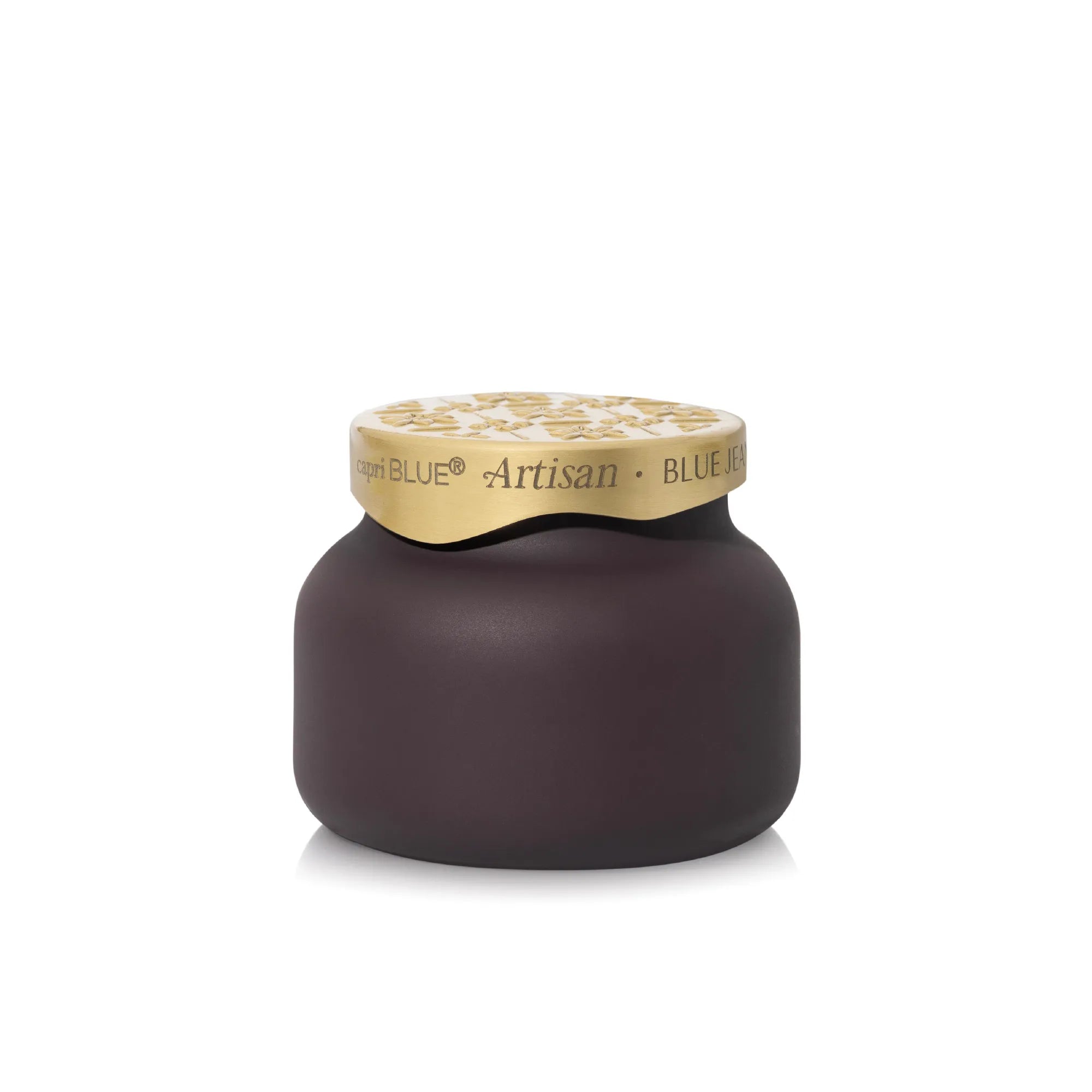 A single jar of Blue Jean Artisan spread on a clean white background. The jar has a dark, matte purple-brown body and a metallic gold lid with the brand name 'Capri Blue Artisan' printed on it.