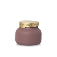 A matte mauve-pink candle jar with a textured gold lid, featuring the brand name 'The Blue' and scent name 'Artisan - HAVANA' printed on the lid.