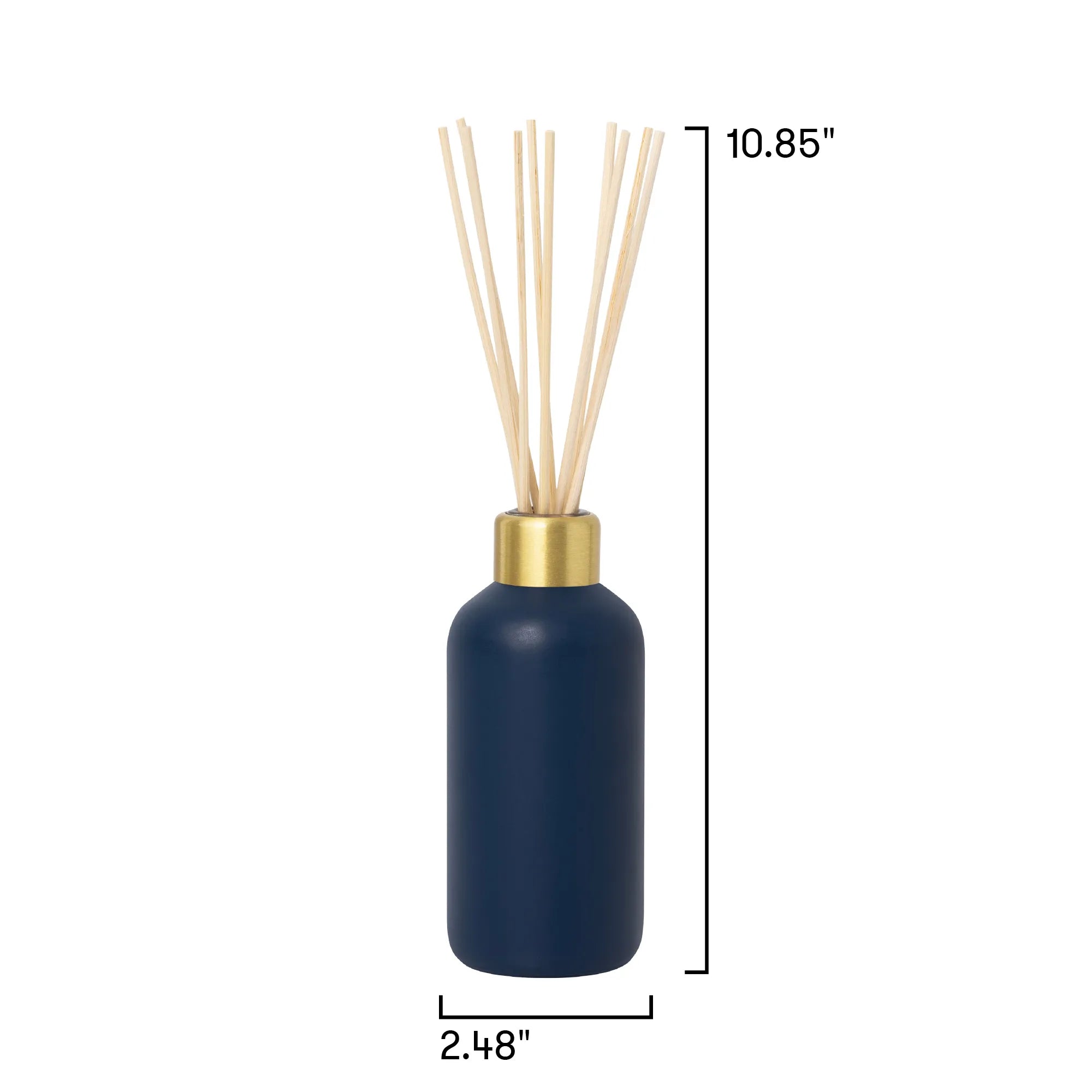 A reed diffuser bottle in matte navy blue with a gold collar and natural beige reeds, shown on a white background with dimension lines indicating height of 10.85 inches and width of 2.