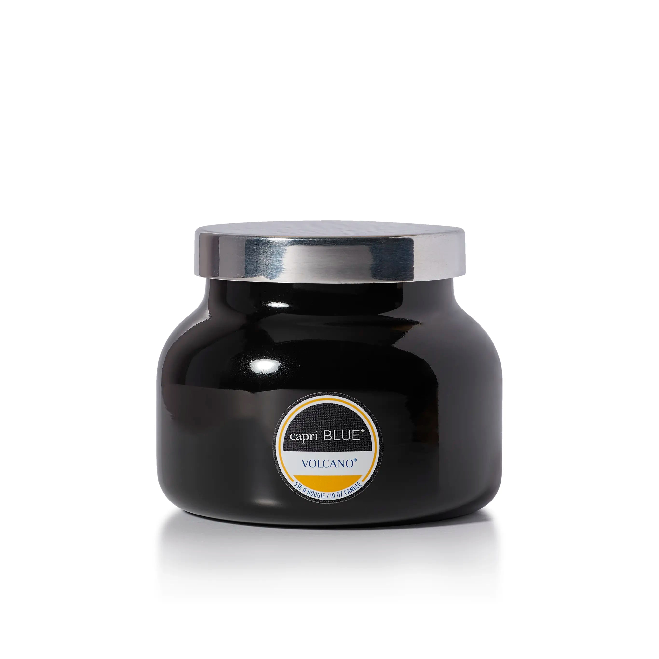 A black glass jar candle with a shiny silver lid and a circular label reading 'capri BLUE' and 'VOLCANO'.