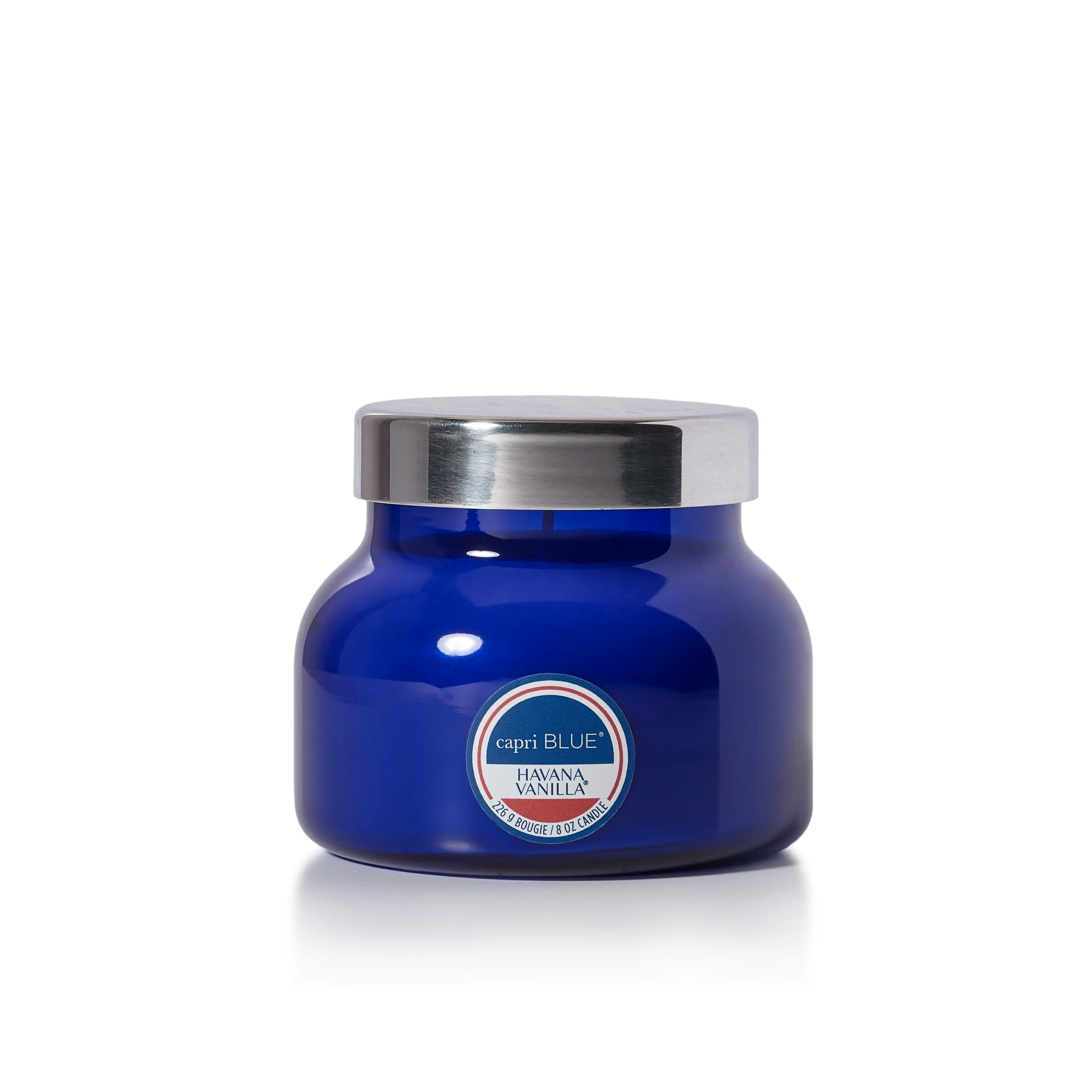 A blue glass jar candle with a silver metal lid and a circular label that reads 'capriBLUE' and 'HAVANA VANILLA'.