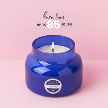 Blue candle in a jar with a pink background and text indicating burn time.