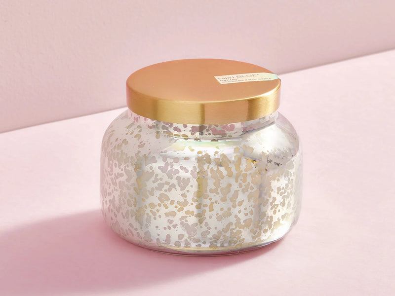 Jar candle with gold lid on a pink background